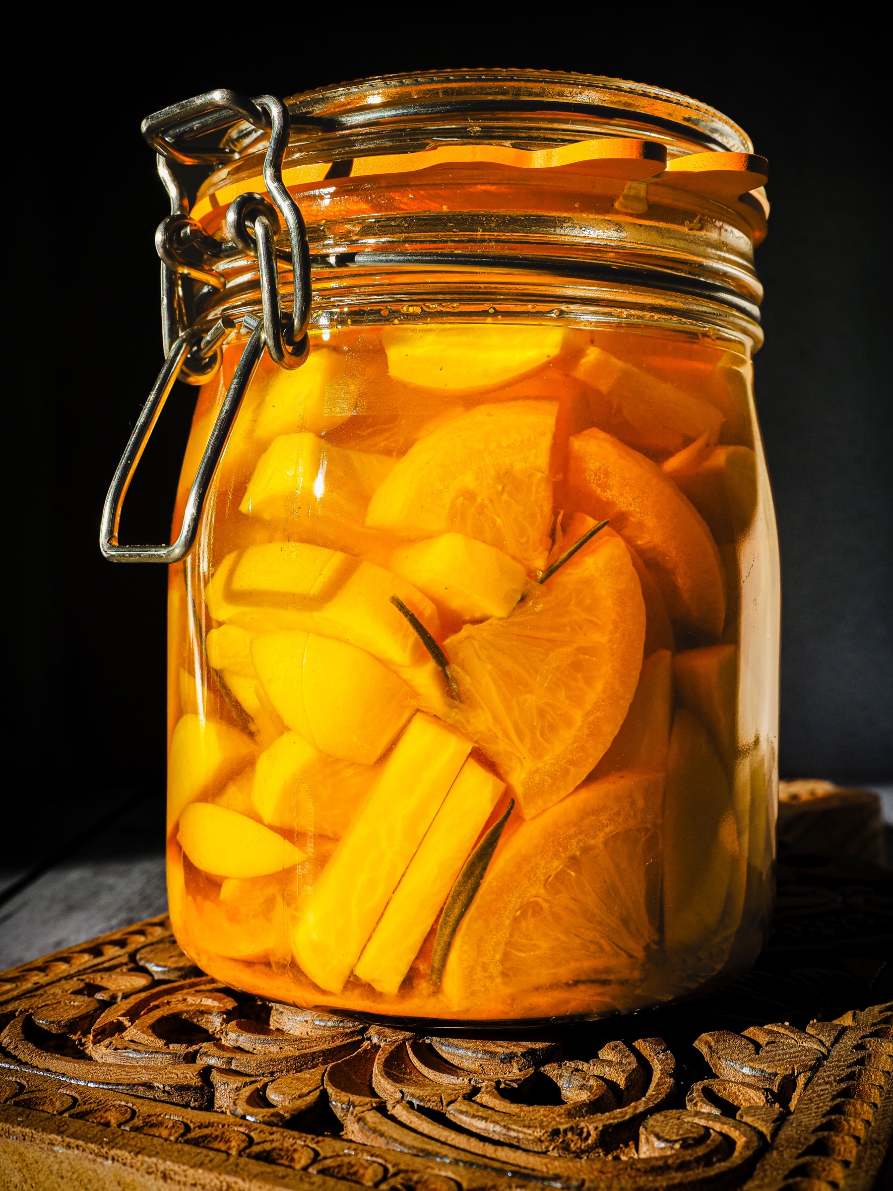 Bocal de légumes orangés photographié sur fond sombre