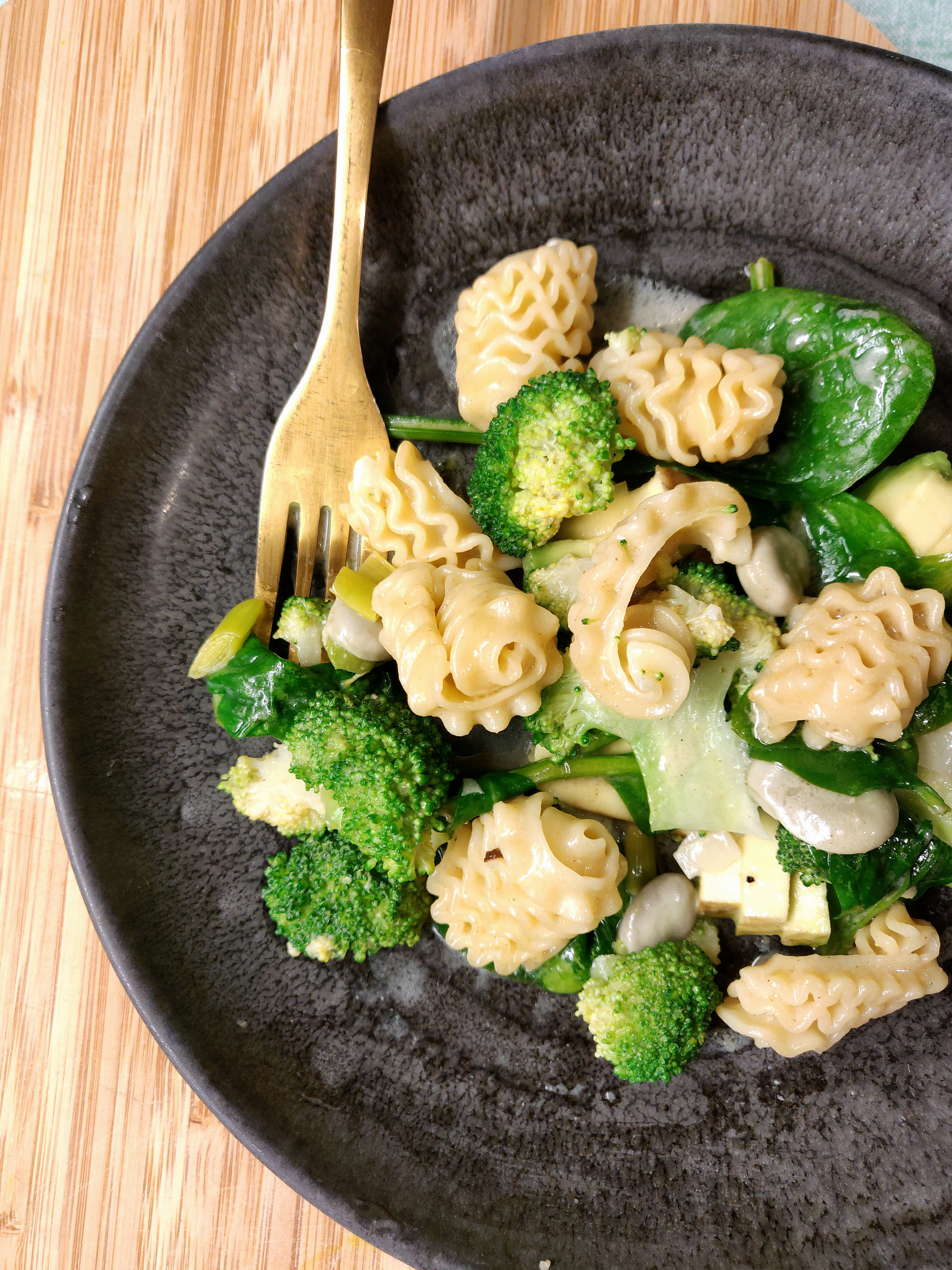 Pâtes au brocoli, aux épinards et au fromage dans une assiette sombre