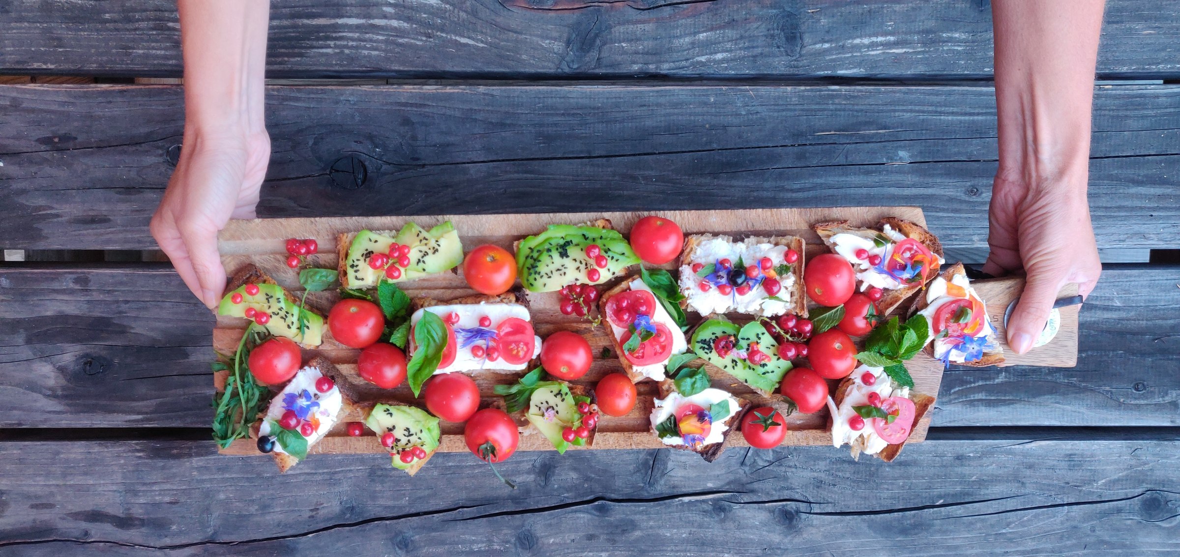 Grand plateau de tartines colorées tenu à deux mains