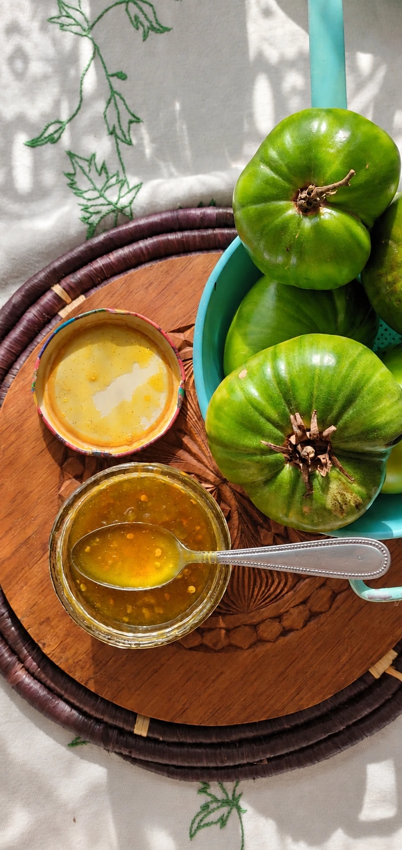 Tomates vertes accompagnées d’un condiment dans une composition lumineuse vue du dessus