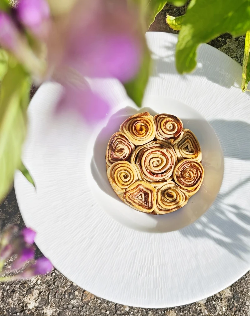 Tarte fleur dressée sur une grande assiette blanche au jardin