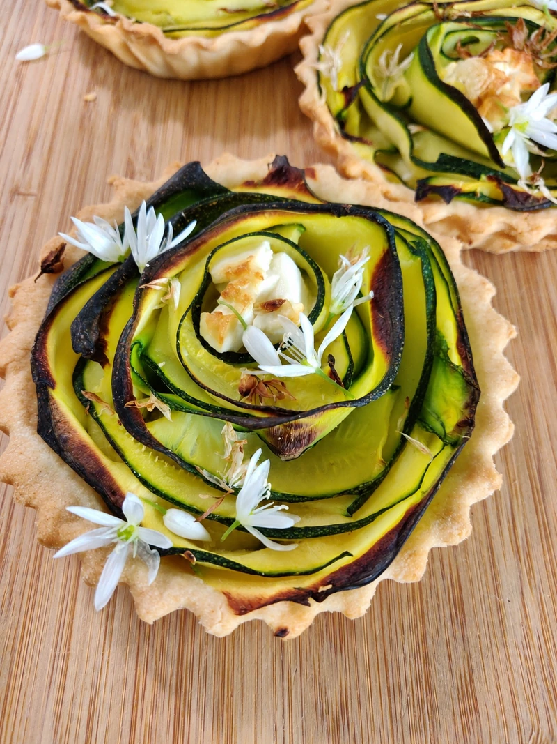 Tartelettes de courgette en spirale décorées de fleurs blanches