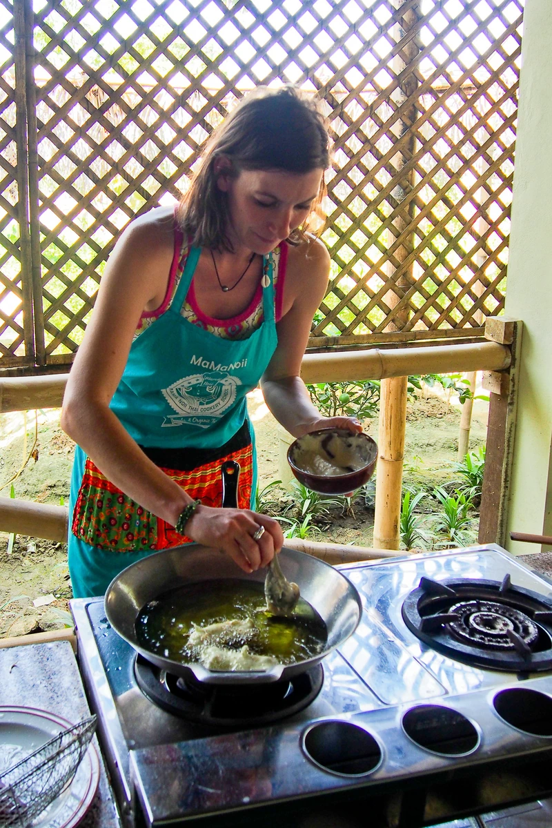 Nadia Probst cuisinant au wok pendant un cours de cuisine à Chiang Mai en Thaïlande
