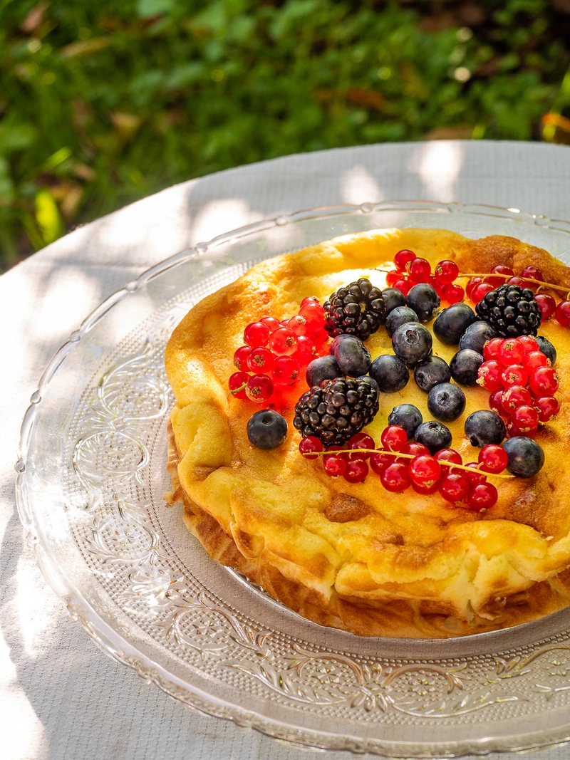 Gâteau doré garni de fruits rouges en extérieur