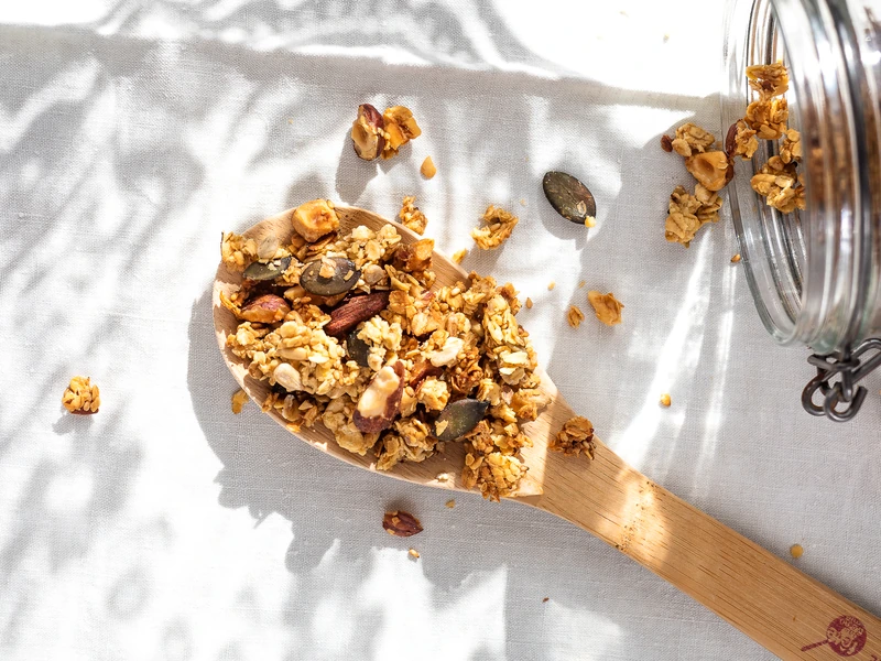 Granola maison présenté sur une cuillère en bois