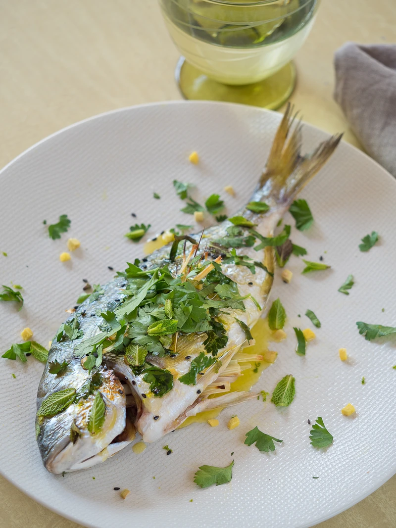 Poisson entier accompagné d’herbes fraîches