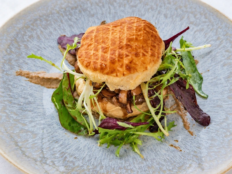 Feuilleté aux champignons et jeunes pousses dressé dans une assiette