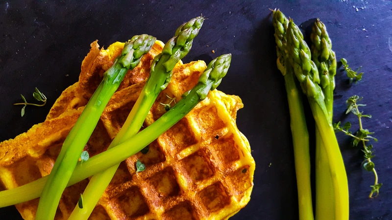 Gaufre dorée servie avec des asperges vertes